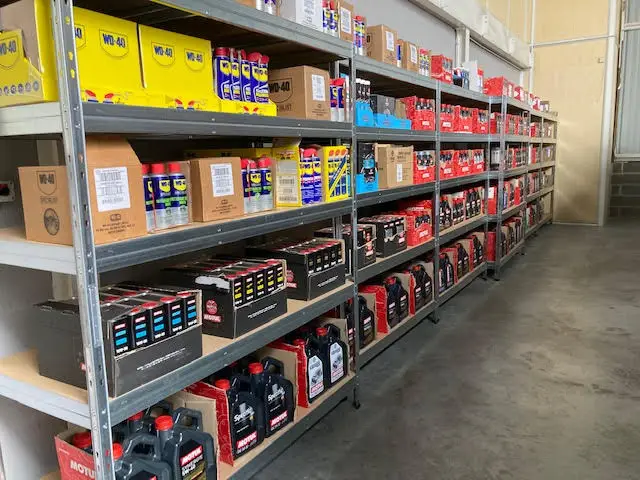 Rayonnages d'entrepôt remplis de WD-40 et de bidons d'huile moteur Motul, catalogue e-commerce du client